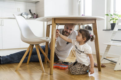 Father and daughter assembling table