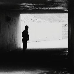 Rear view of silhouette man standing in corridor