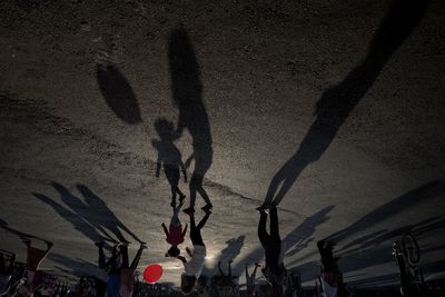 Crowd on illuminated street against sky at night