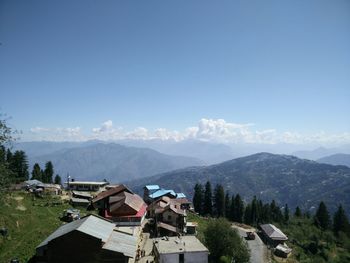 Houses on hill against sky