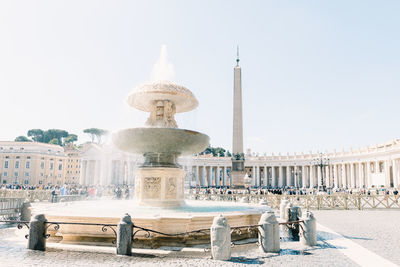 Fountain in city against clear sky