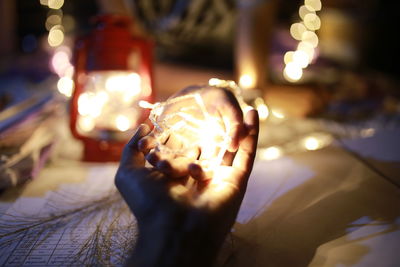 Close-up of hands holding illuminated lighting equipment