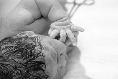 Close-up of newborn baby on bed in hospital