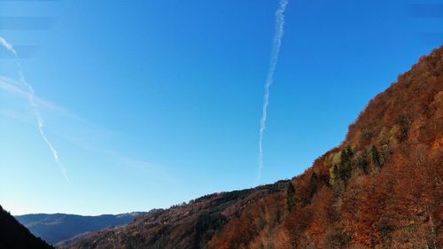 Low angle view of mountain range against blue sky