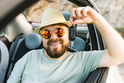 Portrait of man wearing sunglasses while sitting in car