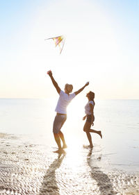 Full length of children on beach against sky