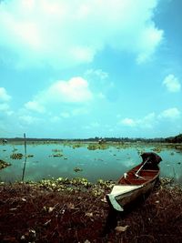 High angle view of shoes on grass by sea against sky