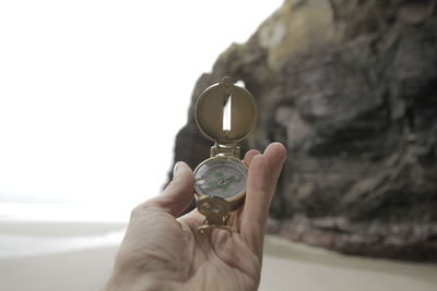 Close-up of hand holding glass against rock