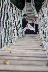 Man sitting on wooden fence