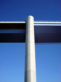 Low angle view of bridge against clear blue sky