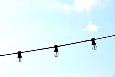 Low angle view of light bulbs against sky