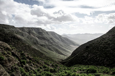 Scenic view of mountains against cloudy sky