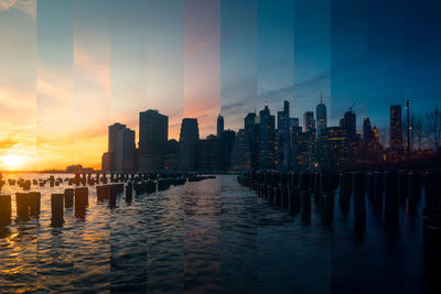 Sea by modern buildings against sky during sunset