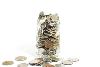 Close-up of coins in container against white background