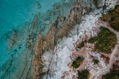 Aerial high angle view of rocks on sea