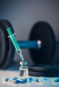 Dumbbells, syringe with needle, pills and vial with steroids. illegal doping in sport concept