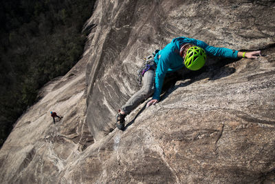 High angle view of man climbing on rocky mountain