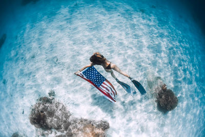 Rear view of woman swimming in sea