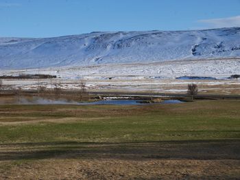 Scenic view of snow covered field against sky