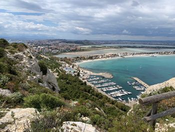 High angle view of cityscape by sea against sky