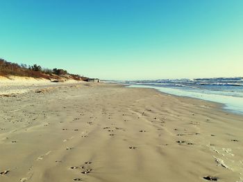 Scenic view of beach against clear blue sky