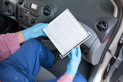 Low section of person repairing car air conditioner