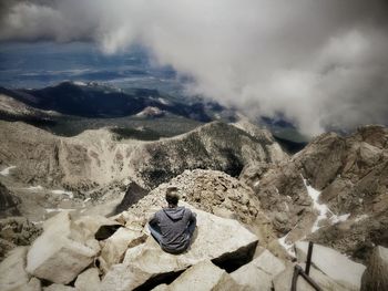 Rear view of woman sitting on mountain