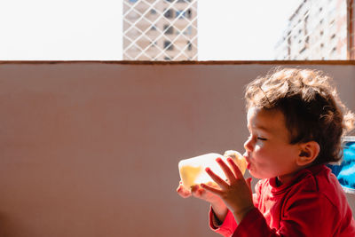 Close-up of cute girl drinking milk at home