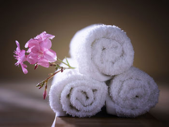 Close-up of pink flowers with towels on table