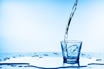 Close-up of drink in glass on table against blue background