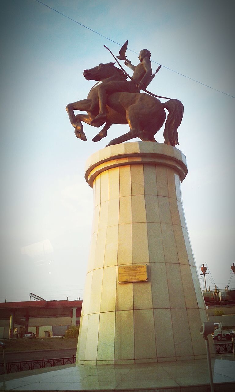 low angle view, built structure, architecture, sculpture, statue, sky, art and craft, human representation, art, famous place, travel destinations, building exterior, clear sky, tourism, creativity, travel, history, religion, sunlight