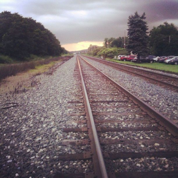 railroad track, transportation, rail transportation, the way forward, diminishing perspective, vanishing point, tree, sky, public transportation, railway track, surface level, cloud - sky, straight, travel, day, outdoors, no people, nature, mode of transport, cloud