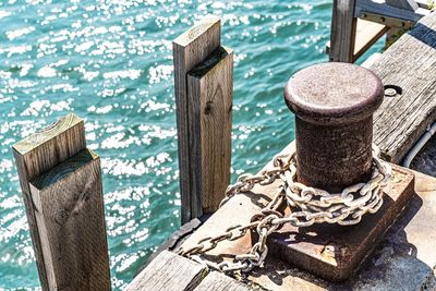 Close-up of wooden post on pier by sea