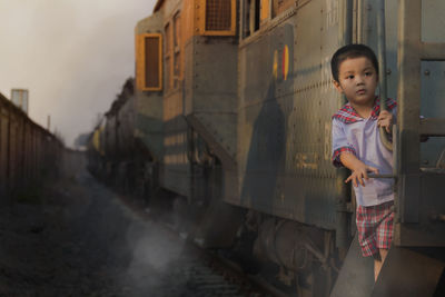 Cute boy standing on train