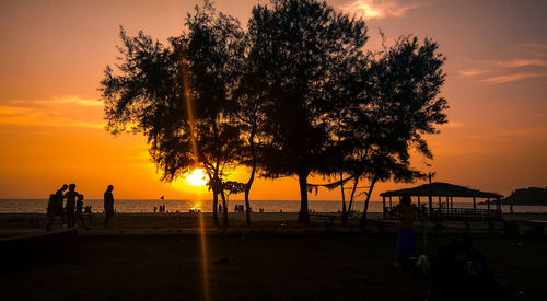 Silhouette people at beach during sunset