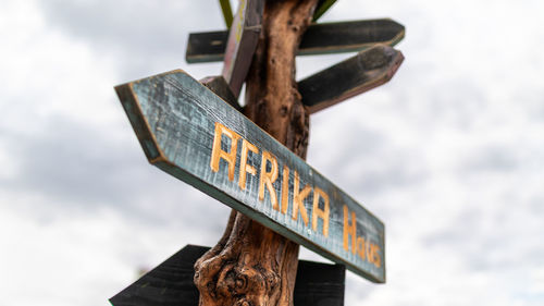 Low angle view of information sign against sky