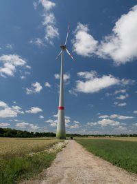 Low angle view of windmill on field against sky