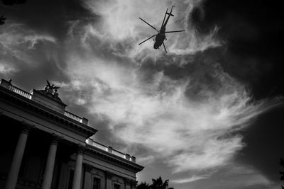 Low angle view of helicopter against clouds