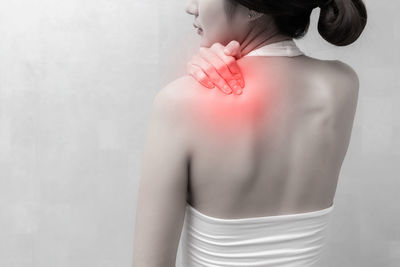 Rear view of woman standing against white background