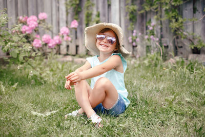 Smiling girl sitting in grass at yard