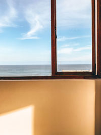 Scenic view of sea against sky seen through window