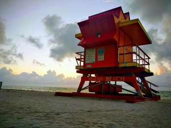 Lifeguard hut on beach against sky