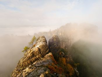 Distant mountain range and heavy clouds of colorful mist above deep valleys. early autumnal day 