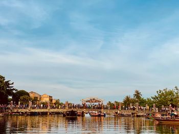 Group of people by river against sky