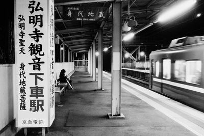 Side view of woman waiting by train at railroad station platform