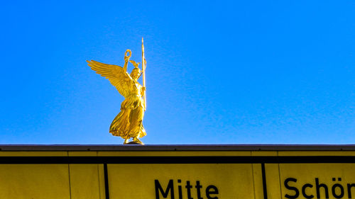 Low angle view of statue against clear blue sky