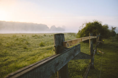 Wooden posts on field against sky