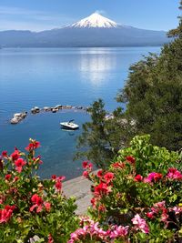 Scenic view of sea by mountain against sky