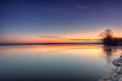 Scenic view of lake against sky at sunset