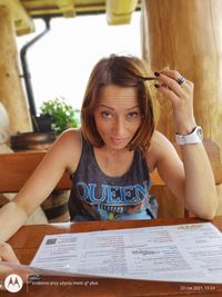 Portrait of young woman sitting on table